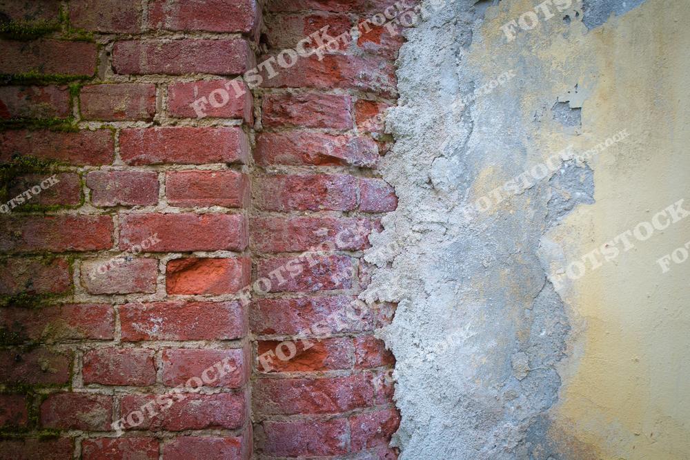 Фотография стены, состоящей из красного кирпича с облупившейся штукатуркой, обнажающей текстуру кирпича. Контраст между грубой кирпичной поверхностью и растрескавшейся штукатуркой создает эффект запущенности и старения. Изображение передает атмосферу заброшенности и истории старого здания.