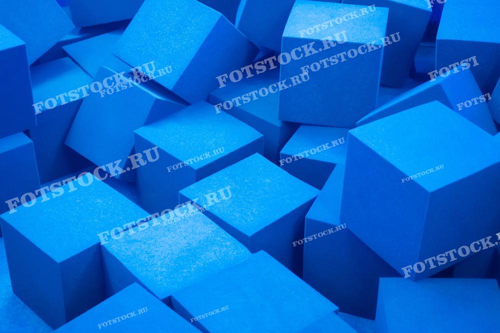На фотографии изображены голубые пенопластовые кубики крупным планом. Эти кубики создают абстрактный фон с ярким и насыщенным цветом.