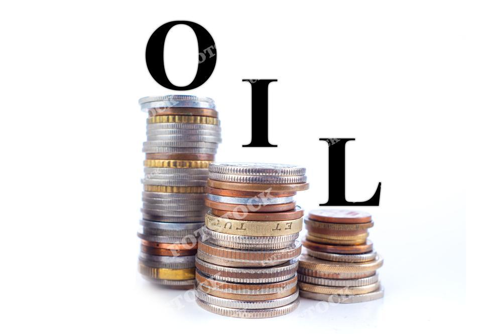 На фотографии изображены две стопки монет разного размера с надписью "OIL" на белом фоне. Композиция символизирует связь между нефтью и финансами, подчеркивая их значимость в мировой экономике. Снимок выполнен в минималистичном стиле с акцентом на монеты и текст.