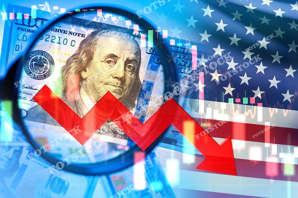 На изображении крупный план купюры в 100 долларов США, красная стрелка направлена вниз, на фоне американского флага и графиков. Композиция акцентирует внимание на экономических вызовах и спаде в финансовом секторе.