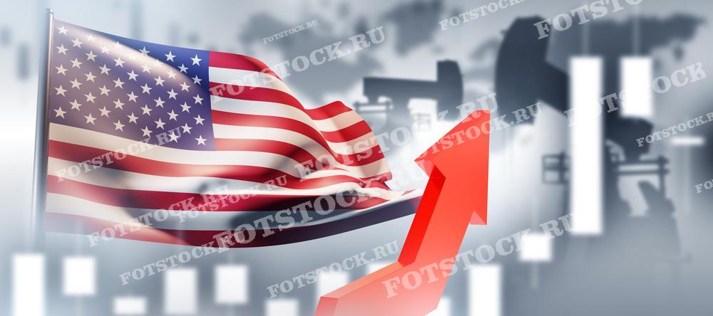 Фотография показывает флаг США на фоне нефтяных вышек и графика с восходящей стрелкой. Это изображение символизирует рост цен на нефть и его влияние на экономику Соединенных Штатов.