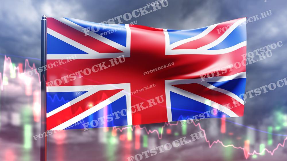 На изображении представлен флаг Великобритании на фоне падающих графиков и облачного неба. Это визуальное представление экономического спада и финансовых трудностей в стране. Графики и темное небо подчеркивают нестабильность и кризисную ситуацию в экономике Великобритании.