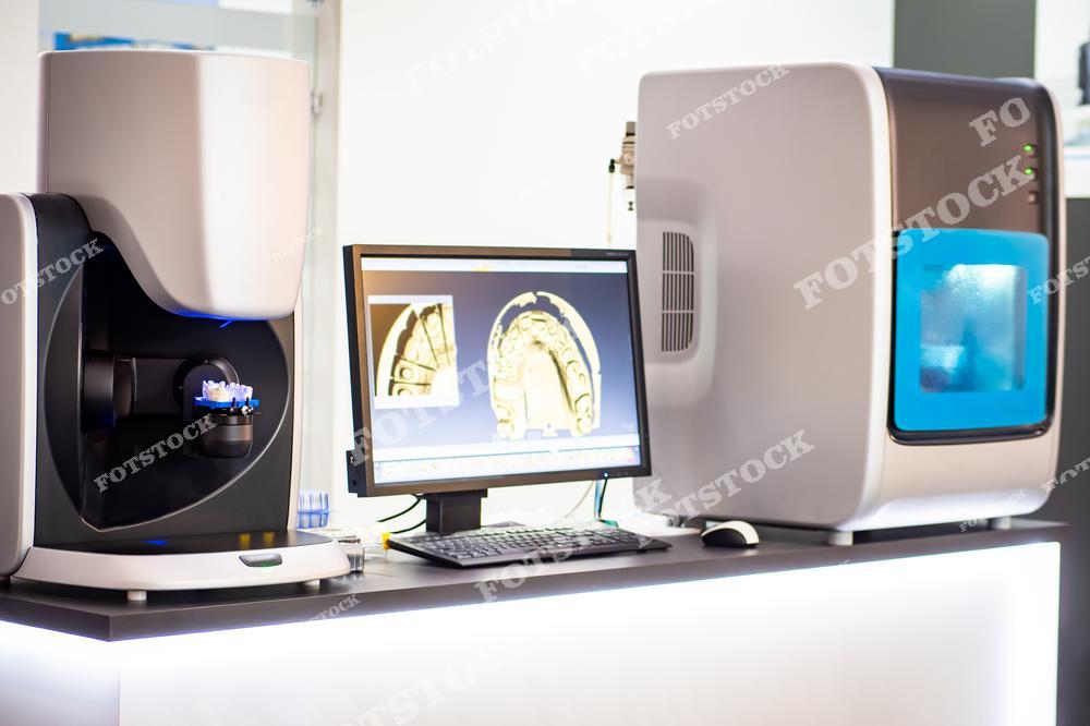 На изображении представлено стоматологическое оборудование, включающее 3D-сканер и компьютер с программным обеспечением для моделирования зубных рядов. Эти технологии используются для создания высокоточных цифровых моделей, которые помогают в изготовлении протезов и других стоматологических изделий.