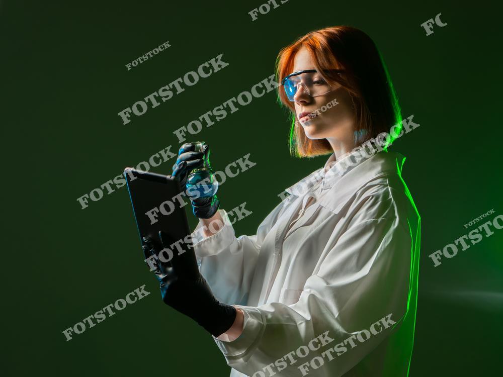 На фото изображена женщина в лабораторной форме с планшетом, стоящая на темном фоне. Это изображение подчеркивает использование мобильных приложений в научных исследованиях и лабораторной работе. Женщина-лаборант использует технологические инструменты, такие как планшет, для облегчения работы в области науки и исследований, что отражает современные тенденции в научной сфере.