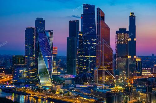 На фотографии запечатлен вид на ночной город Москву с небоскребами, расположенными в деловом центре столицы. Этот городской пейзаж иллюстрирует современный облик Москвы, ее архитектурную составляющую и динамичную жизнь ночного города. Фотографию можно использовать для иллюстрации туристических материалов о Москве, деловых презентаций о городе, а также в качестве декоративного элемента в интерьерном дизайне или публикаций о городской архитектуре и инфраструктуре.