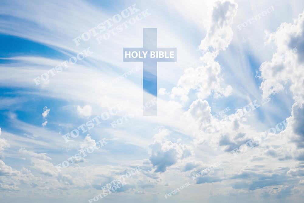 На фотографии изображен крест с надписью "Holy Bible", размещенный на фоне яркого голубого неба с облаками. Лучи света подчеркивают святость и духовное значение изображения. Эта композиция символизирует надежду, веру и связь с Богом.